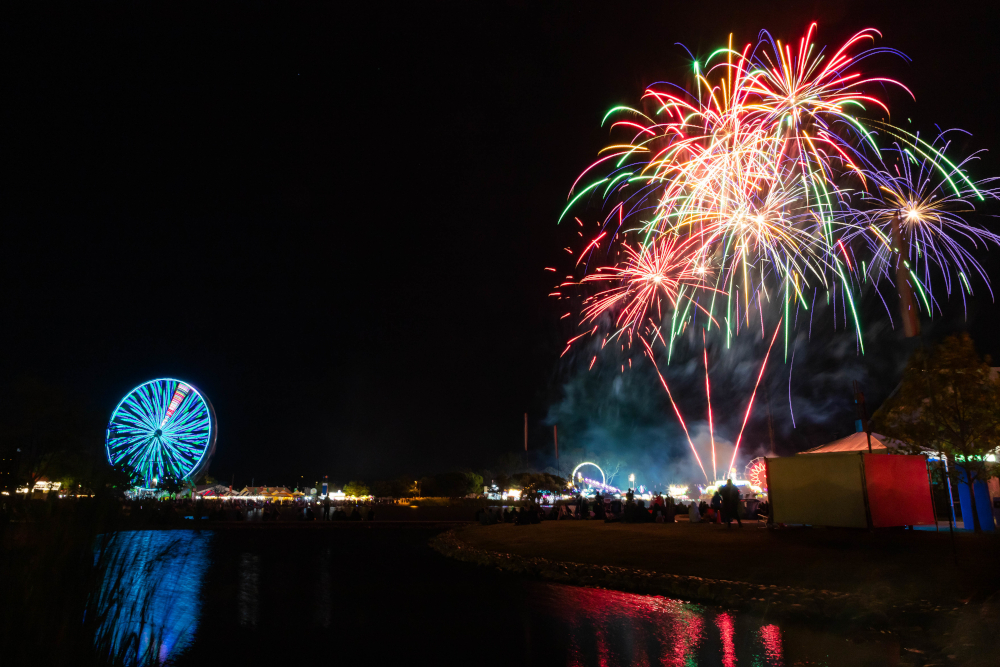 Fireworks, giant ferris wheel across lagoon