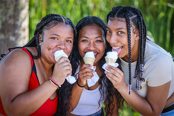 three teenage girls eating ice cream cones